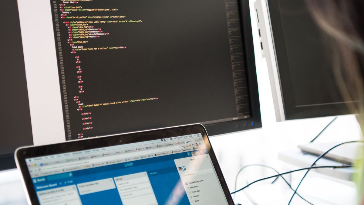 Developer programming a game system across two screens